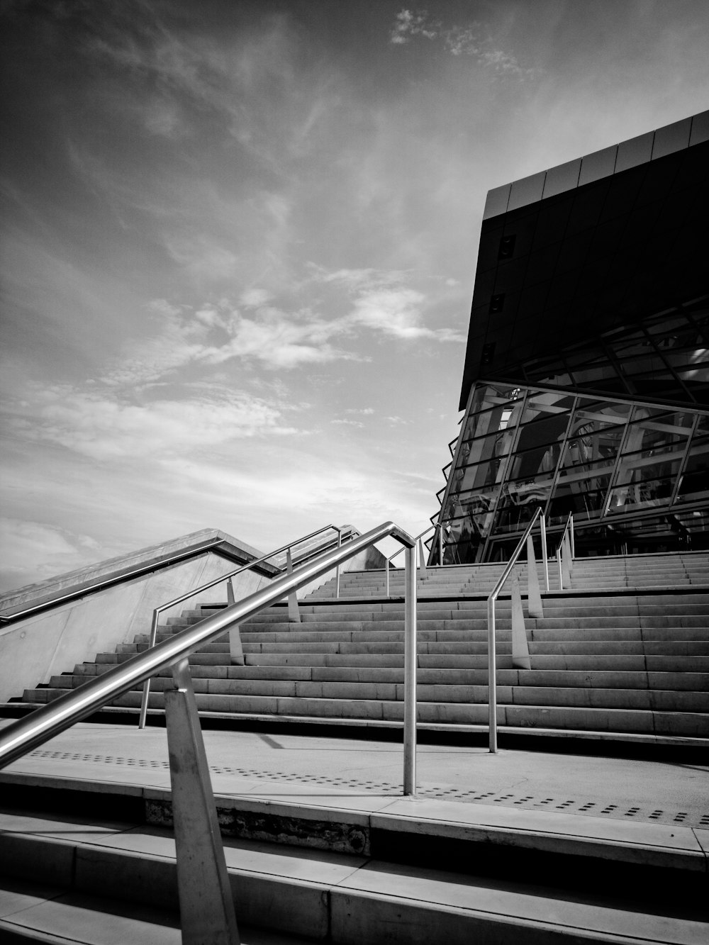 a black and white photo of stairs and a building