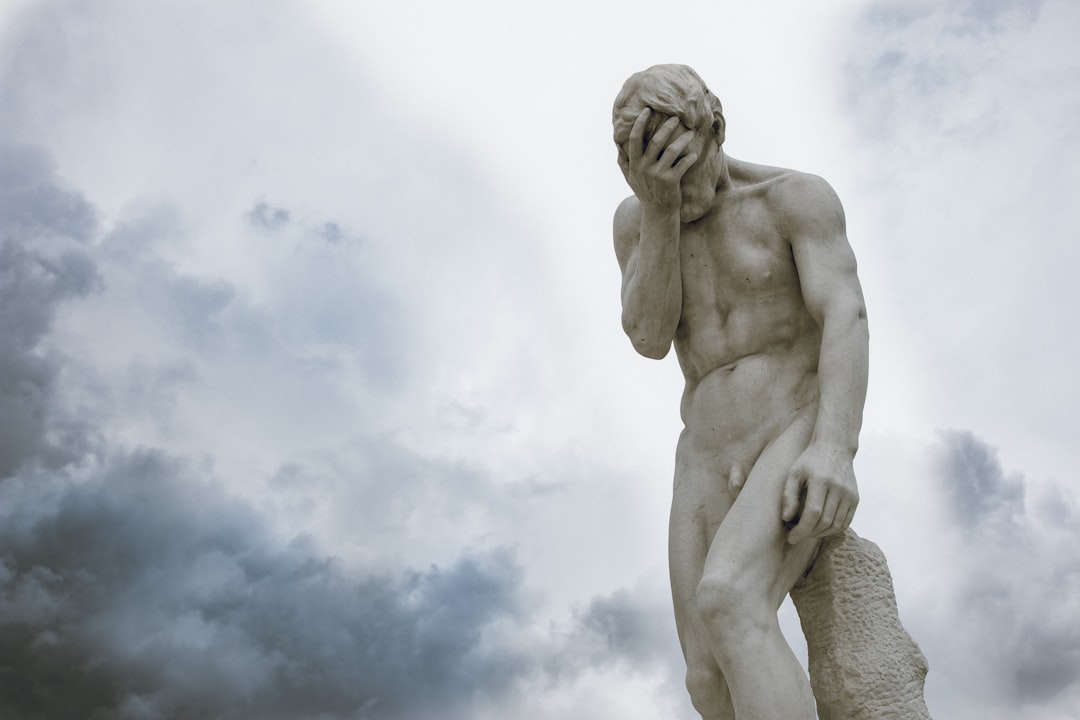 a statue of a man holding his head in his hands,