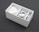 A neatly arranged white box containing a power adapter, a coiled charging cable, and an audio cable. The box is sectioned into compartments, neatly organizing the electronic accessories.