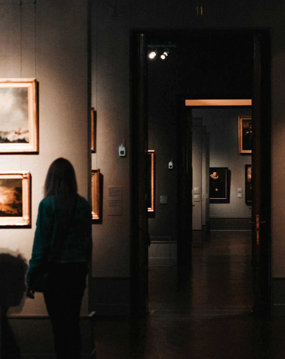 woman standing near paintings