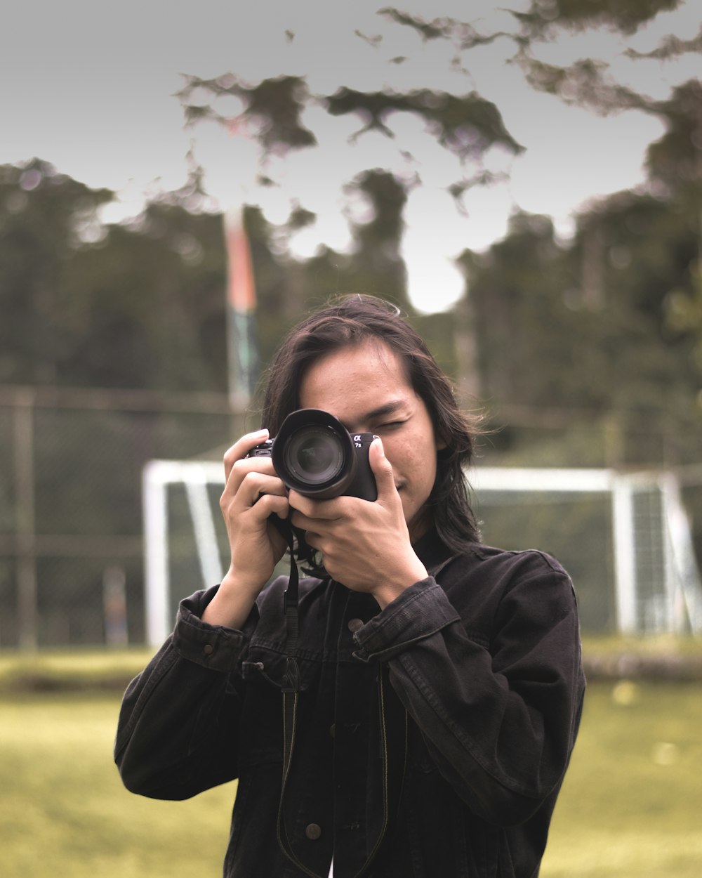 shallow focus photo of man using black DSLR camera