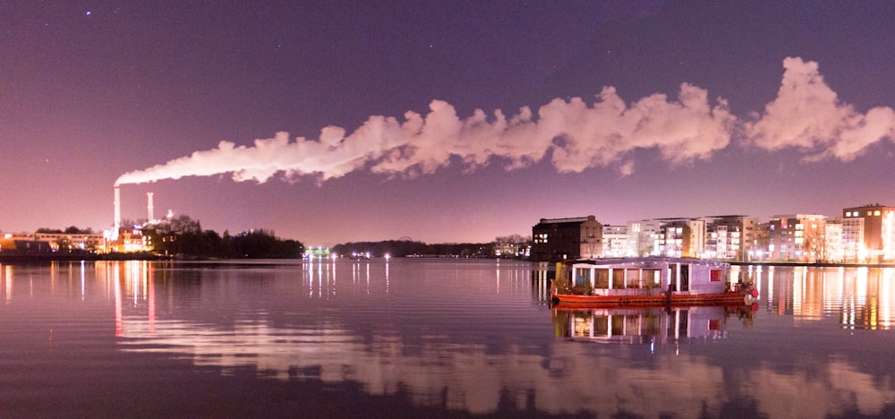 a boat floating on top of a lake at night