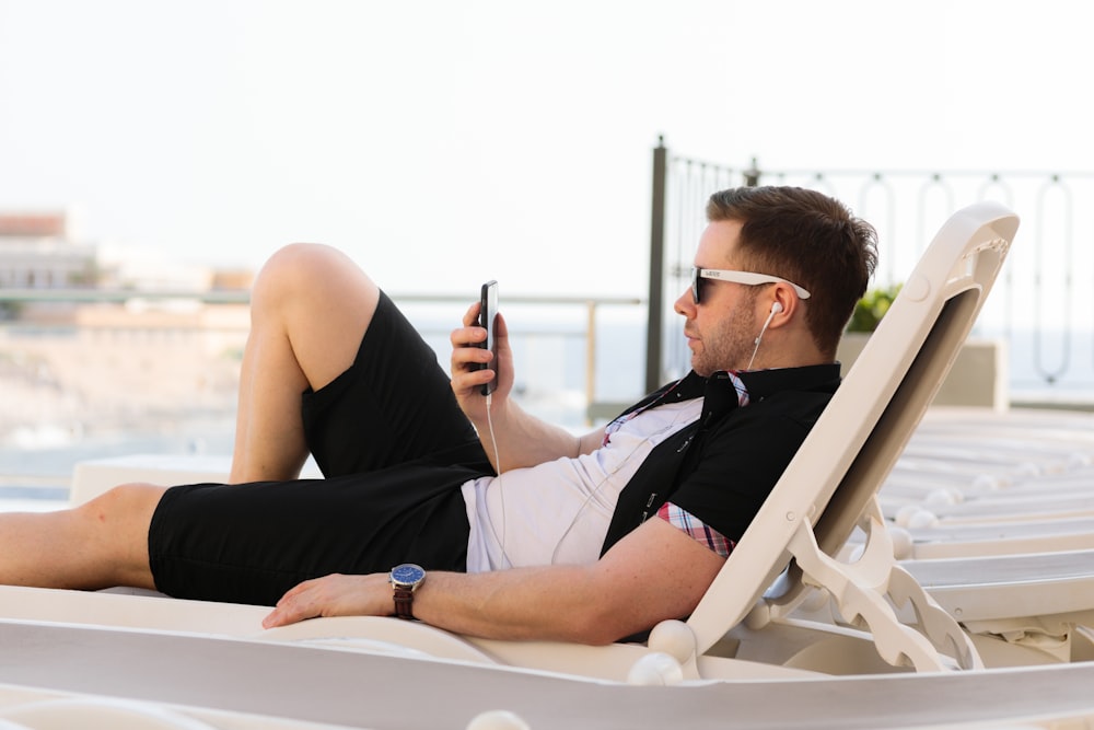 man lying on white sun lounger