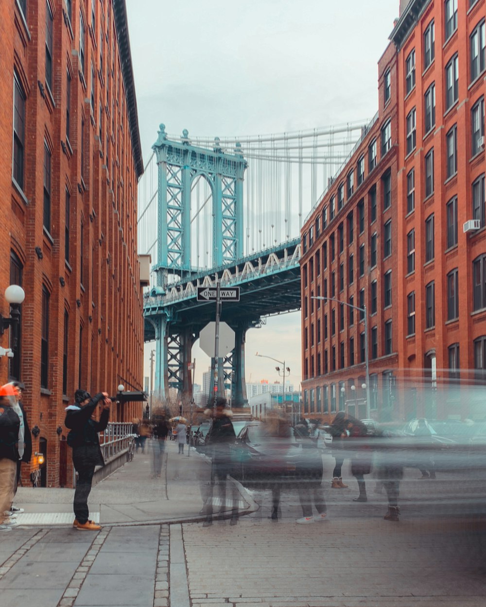 people near orange building and bridge during daytime