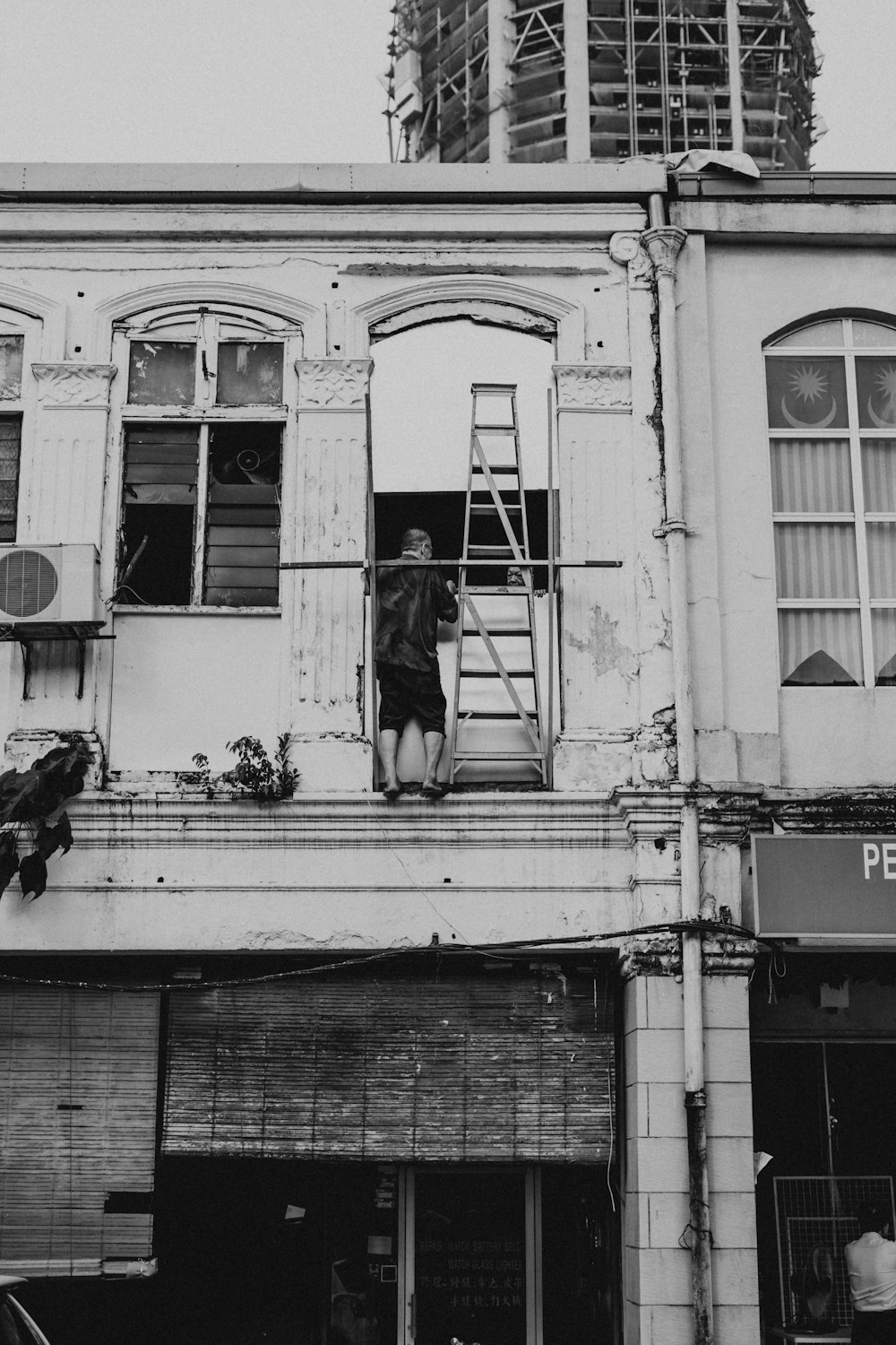 grayscale photography of man on house