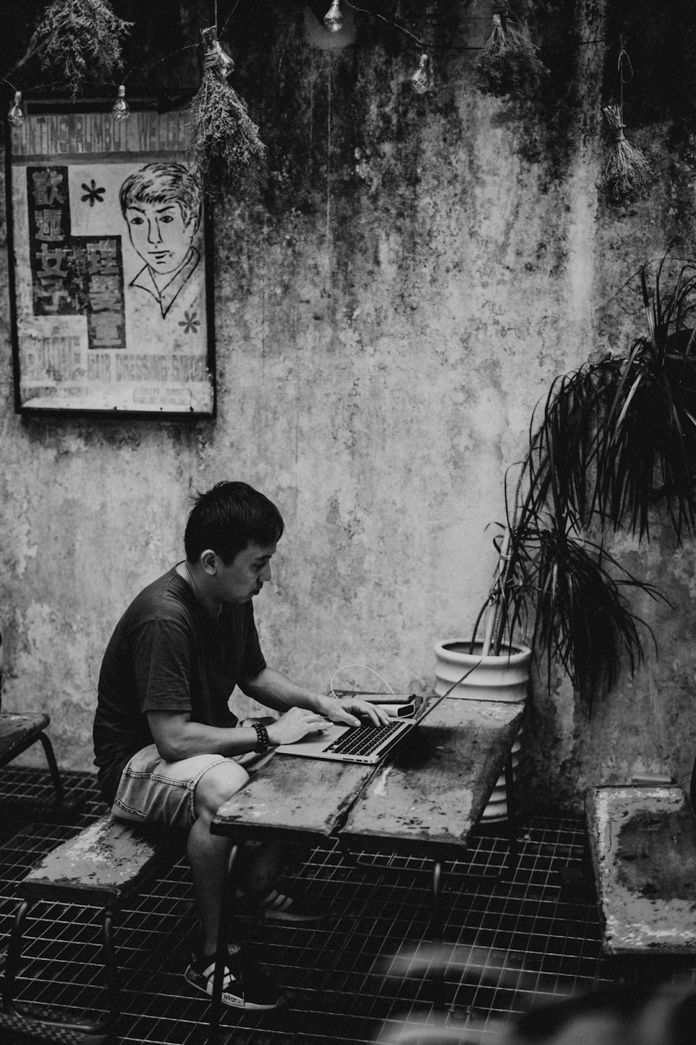 grayscale photography of man using laptop computer