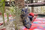 A vibrant outdoor bolster pillow displayed in a garden setting.