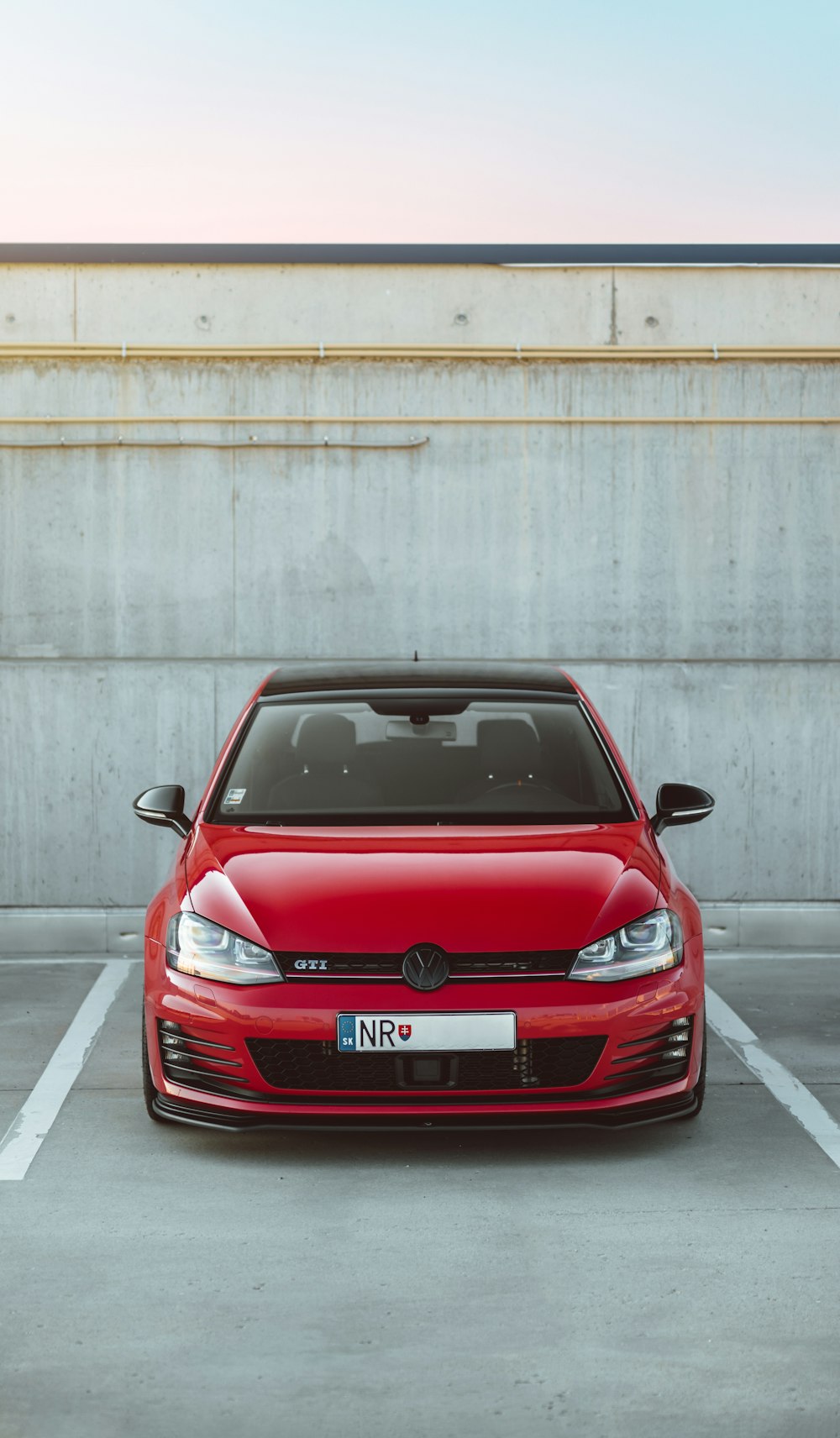 estacionamento vermelho no estacionamento perto da parede