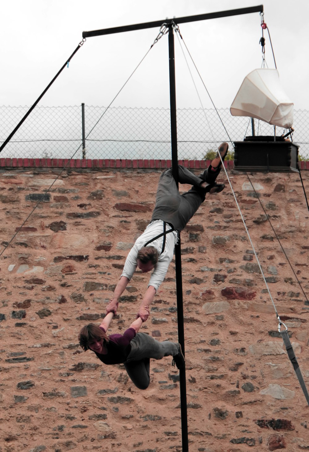 man hanging on rod carrying woman