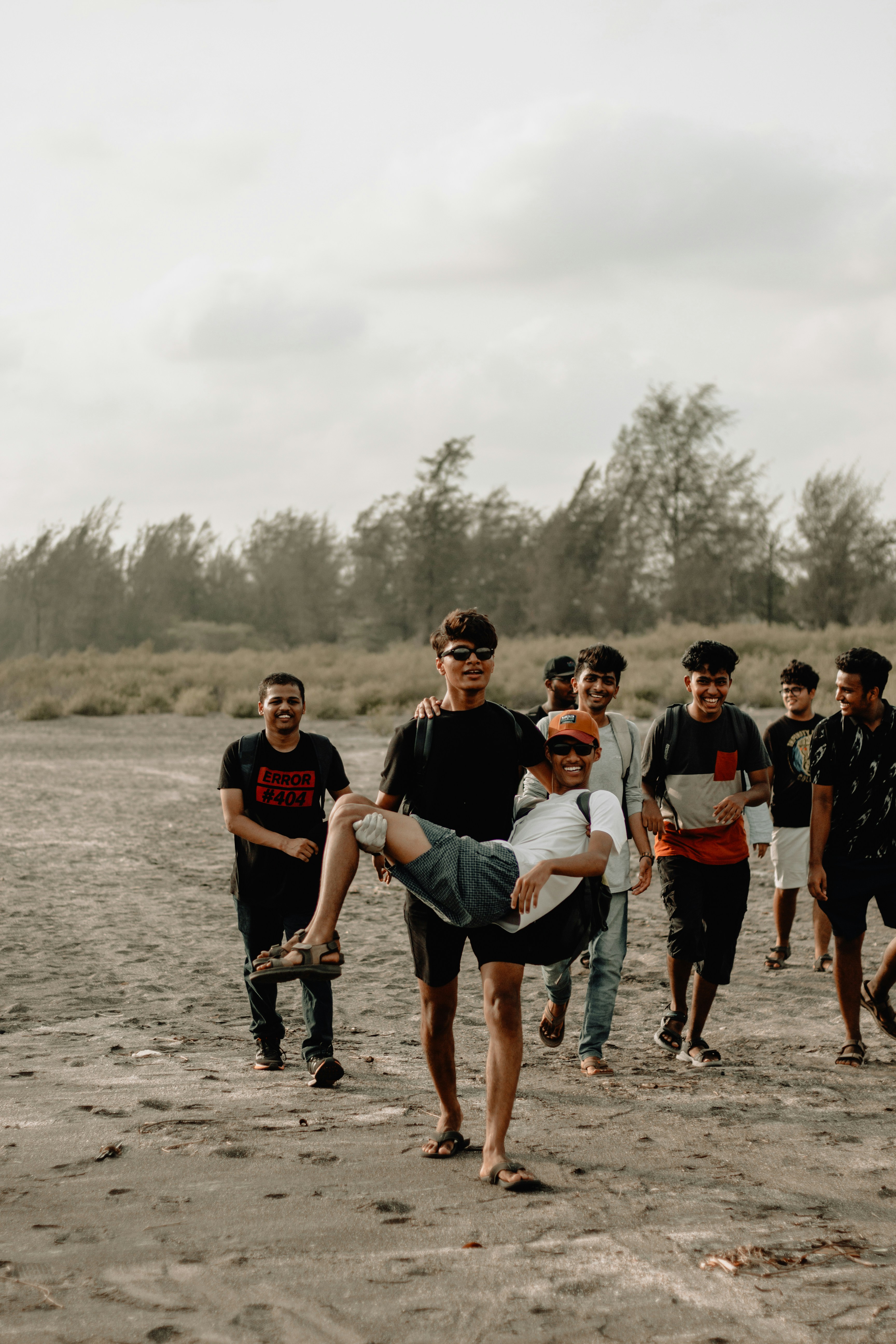 sekelompok pria berjalan di dekat pohon