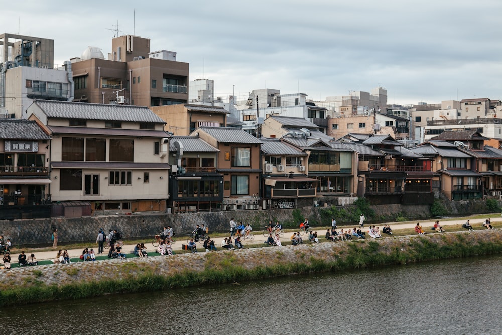 people walking and sitting near body of water