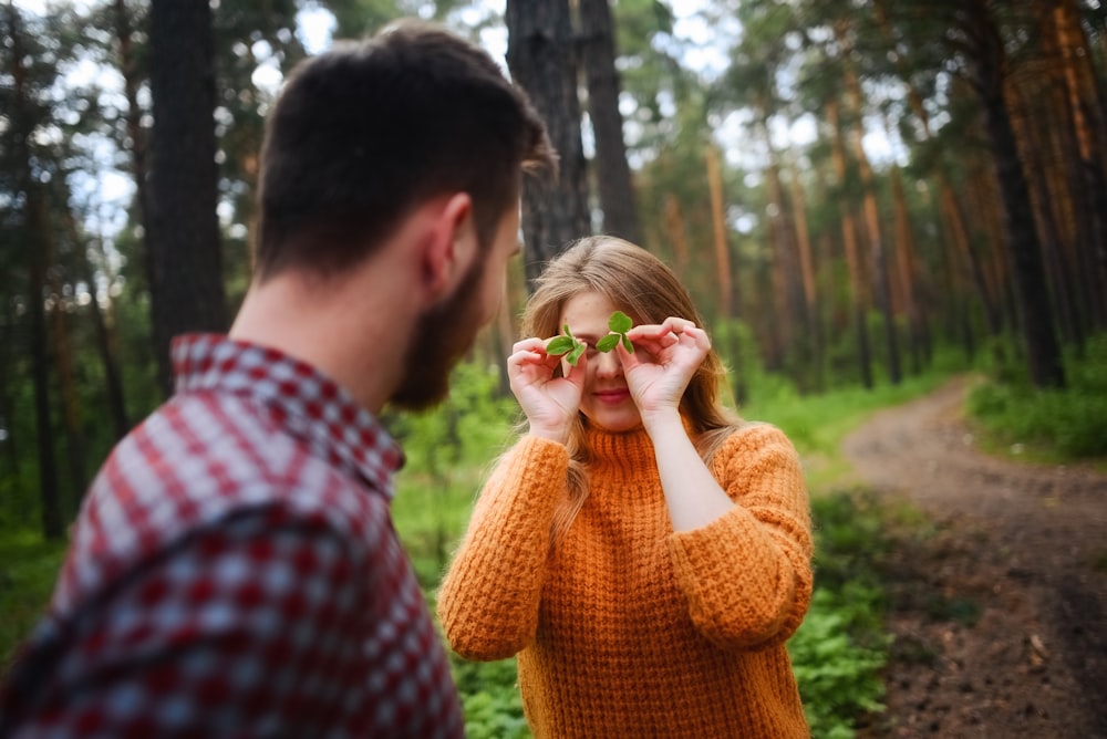 woman covering face with leaves