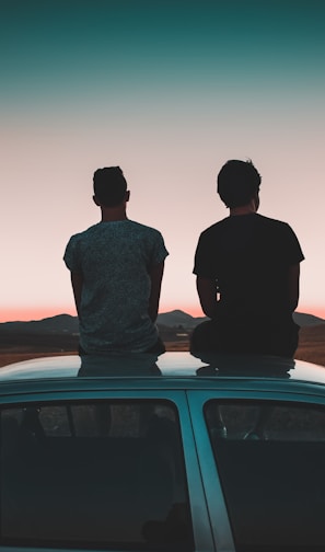 two men sitting on vehicle