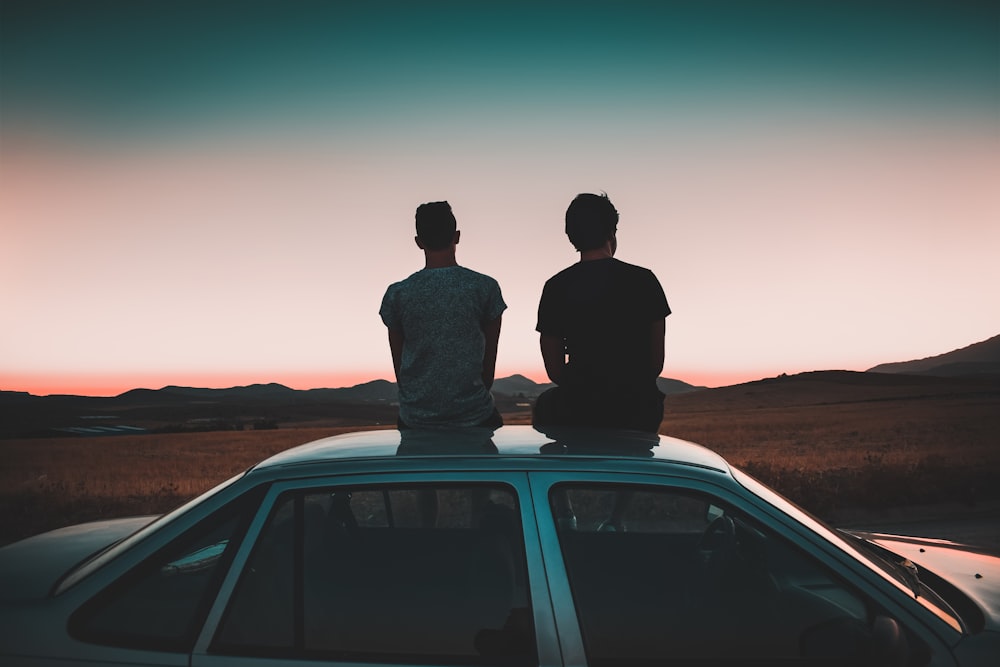 two men sitting on vehicle