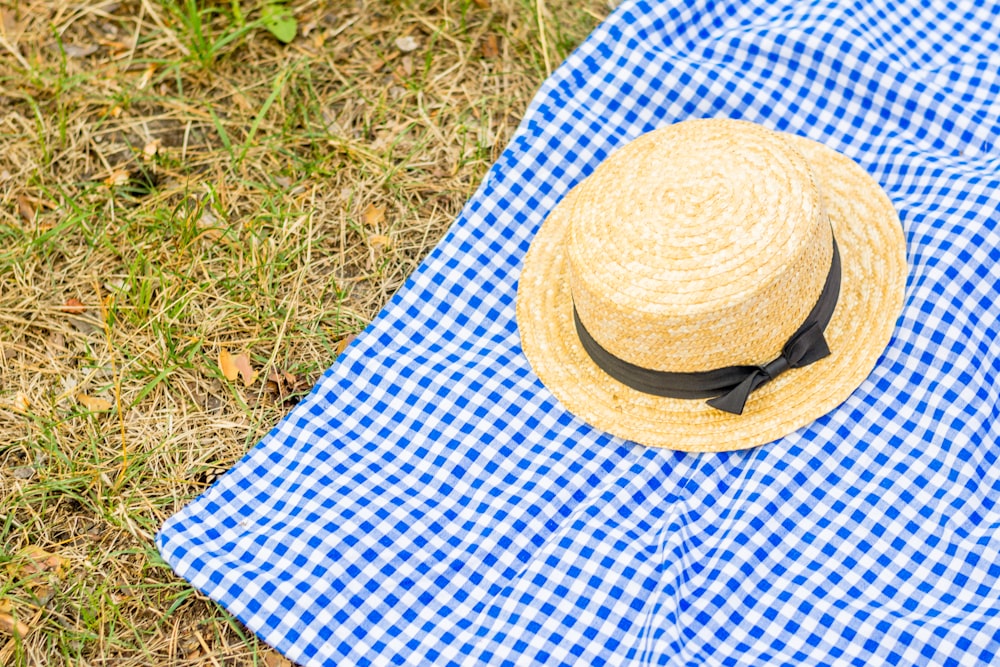 beige fedora hat on picnic mat