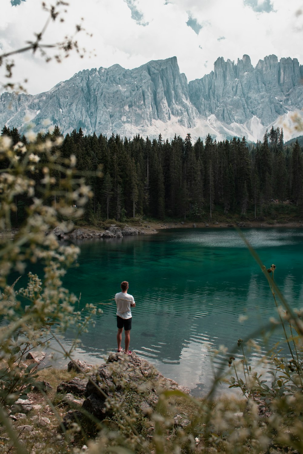 person standing on rock near body of water