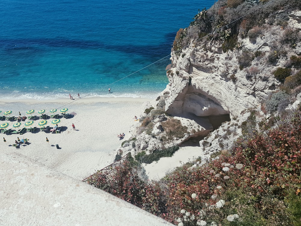 Fotografia aerea di persone che si riuniscono in riva al mare durante il giorno