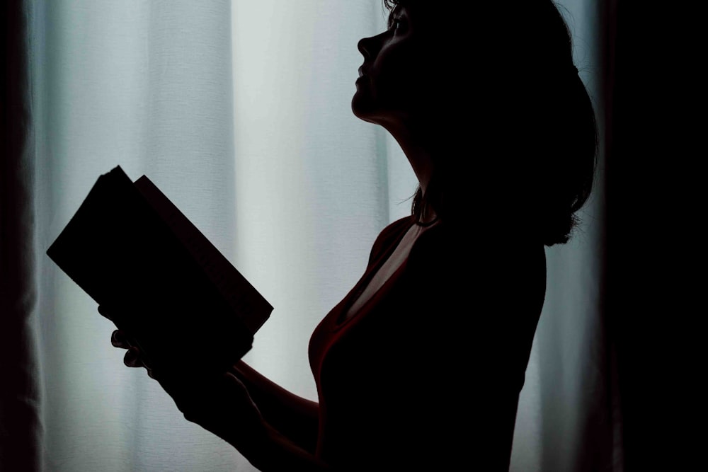 Silhouette einer Frau, die ein Buch hält