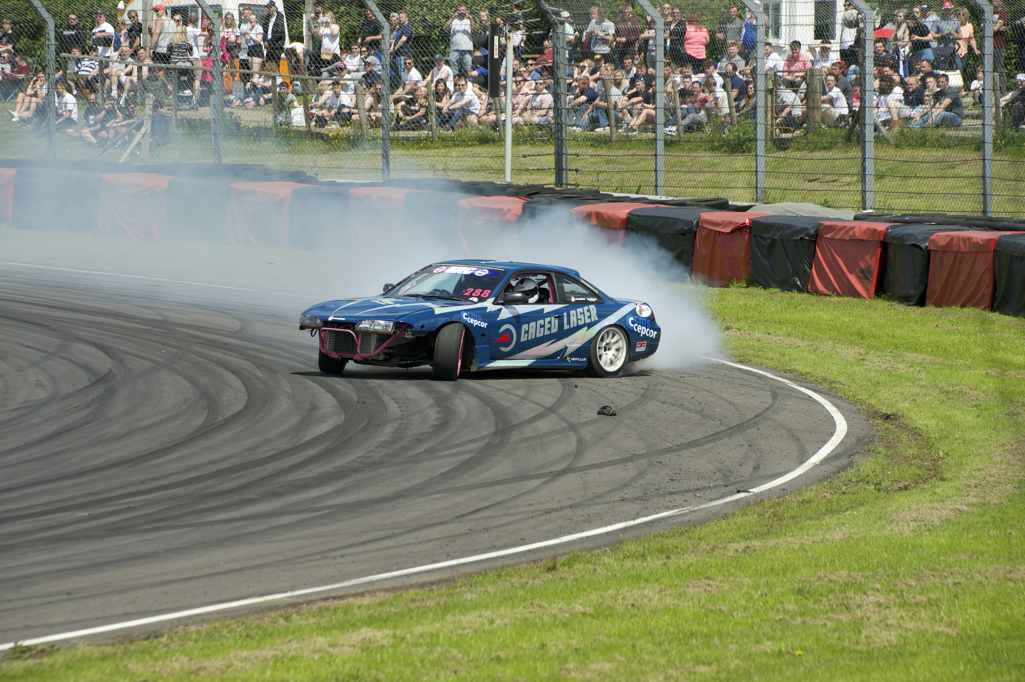 closeup photo of drifting car on track during daytime