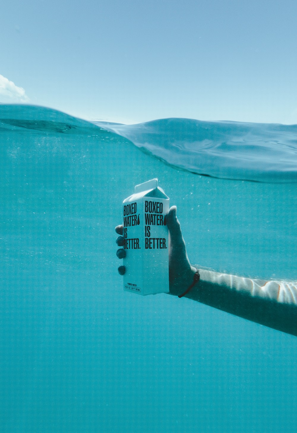 person holding boxed water underwater