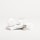 A white, sleek container with the brand name 'Candid', a small bottle labeled 'Whitener', and a clear dental aligner rest on marble slabs. The composition is minimalist with an emphasis on dental care products.