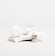 A white, sleek container with the brand name 'Candid', a small bottle labeled 'Whitener', and a clear dental aligner rest on marble slabs. The composition is minimalist with an emphasis on dental care products.