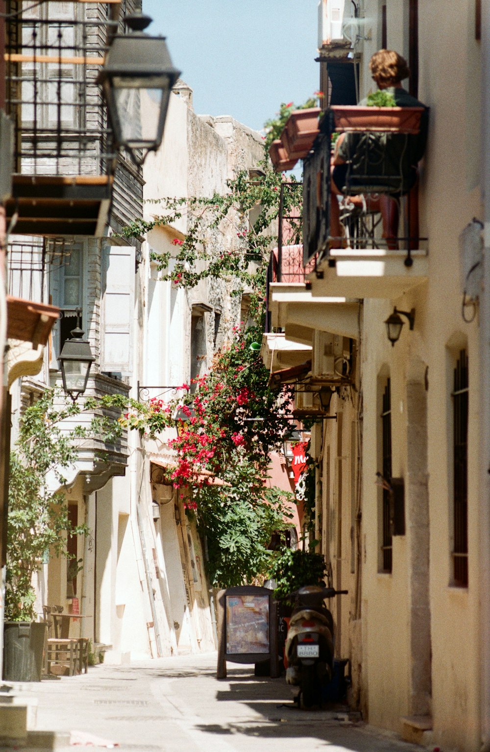 Una stretta strada della città con fiori sui balconi