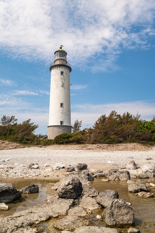 white lighthouse at the shore during daytime in Fårö Sweden