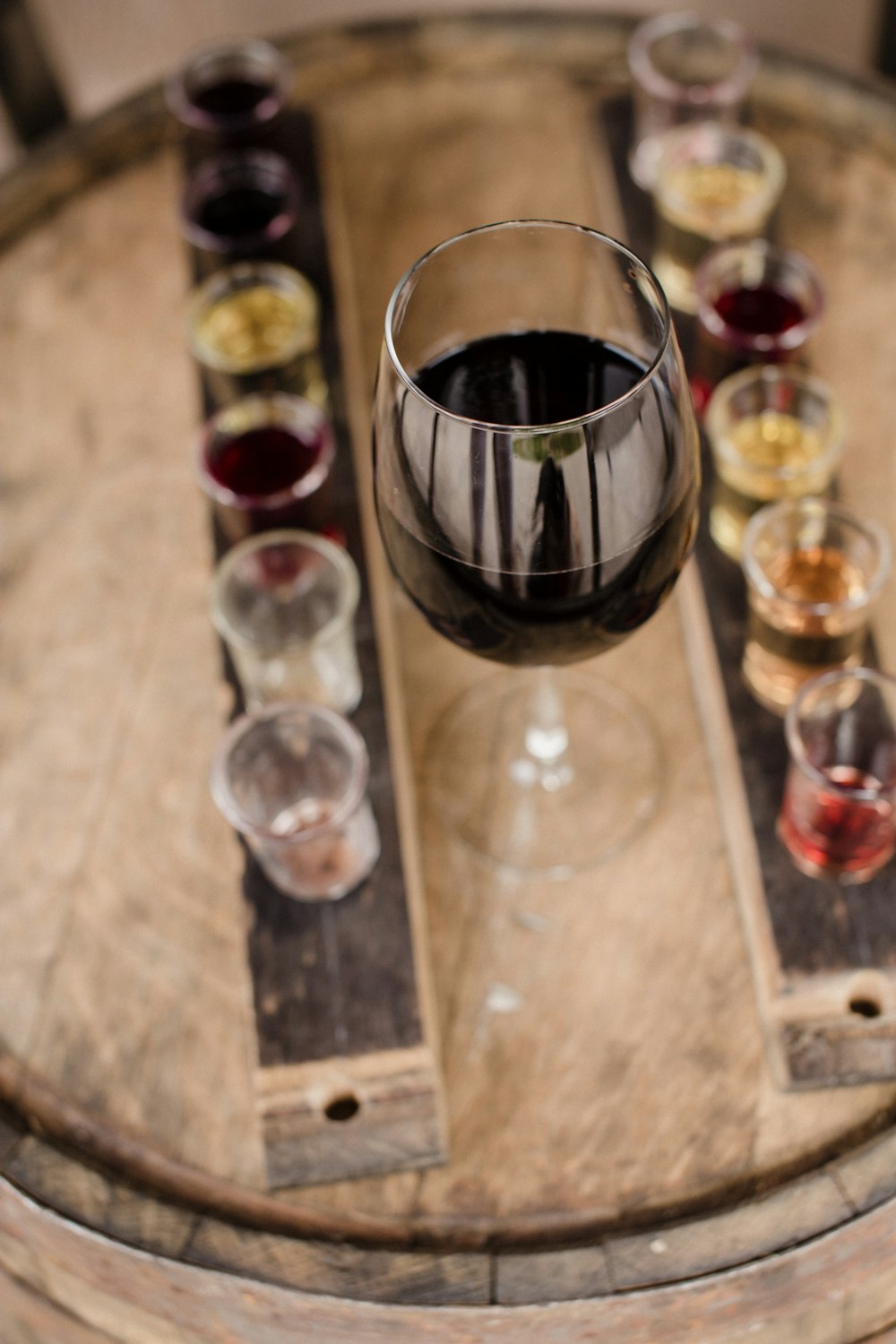 red wine on glass near shot glasses