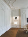 Close-up of elegant room details including textured wallpaper and designer lamps.