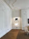 Before and after photo of a renovated classic living room with fresh paint and elegant moldings.
