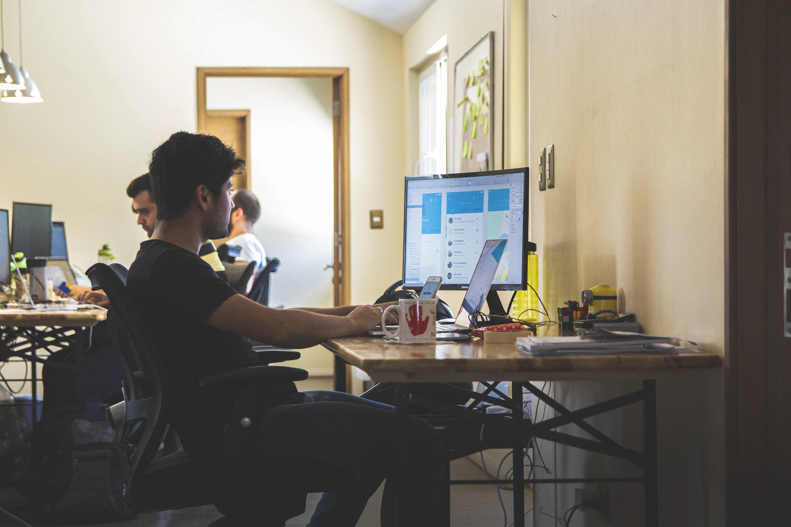 A product team member working at a monitor in a shared office