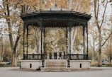 black and white gazebo surrounded with tall and orange trees