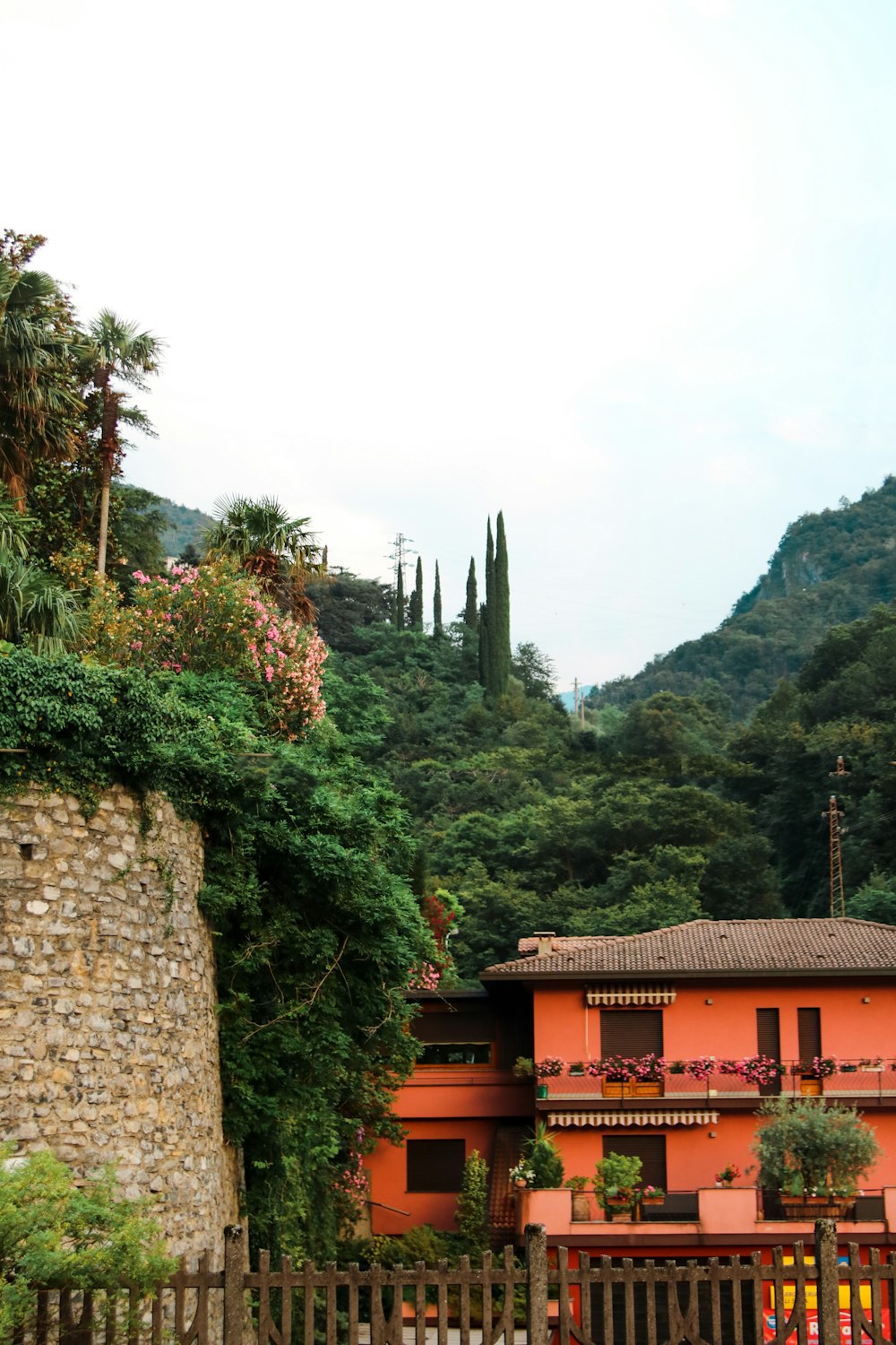 pink concrete house near green mountain during daytime