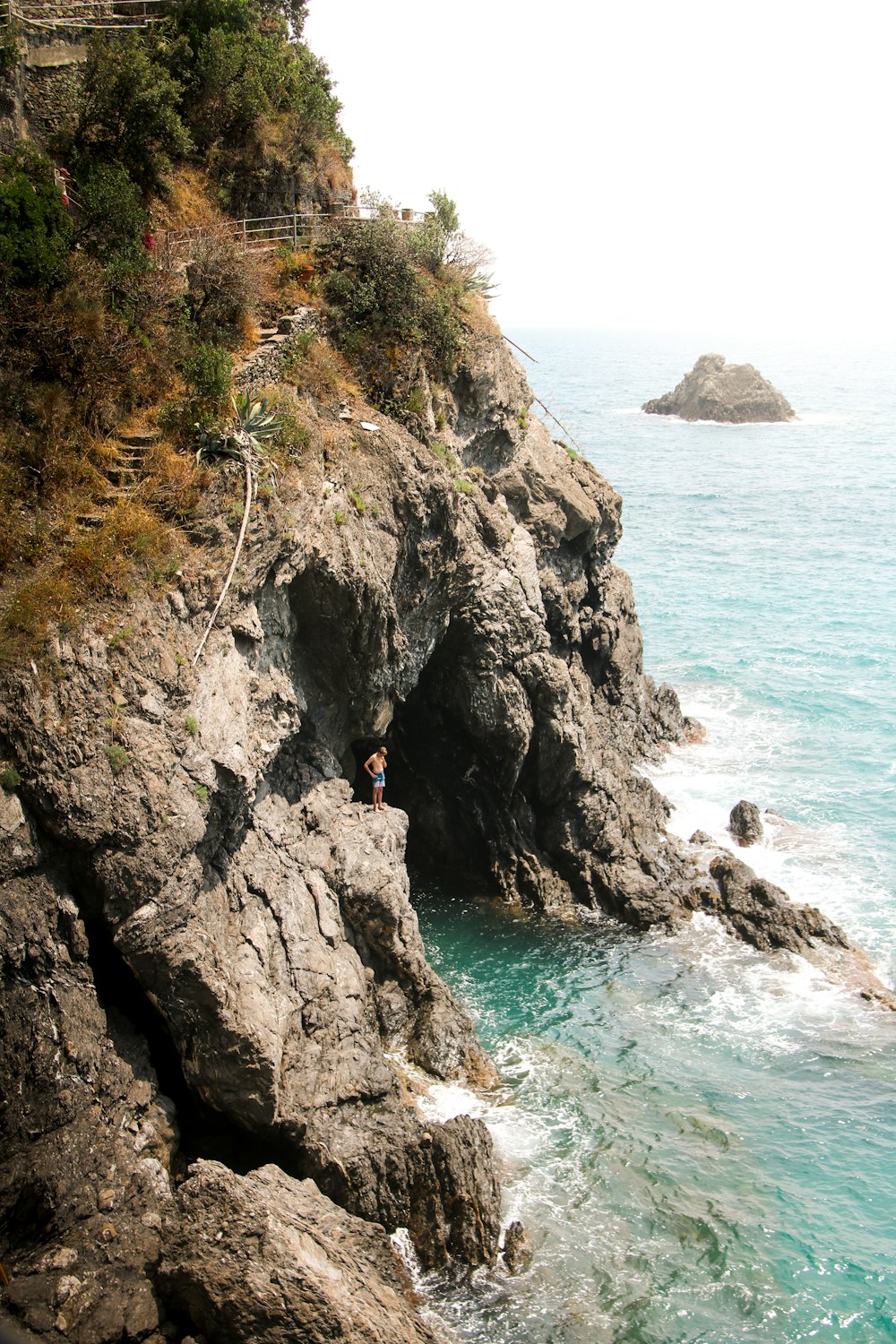 a person standing on a cliff next to the ocean