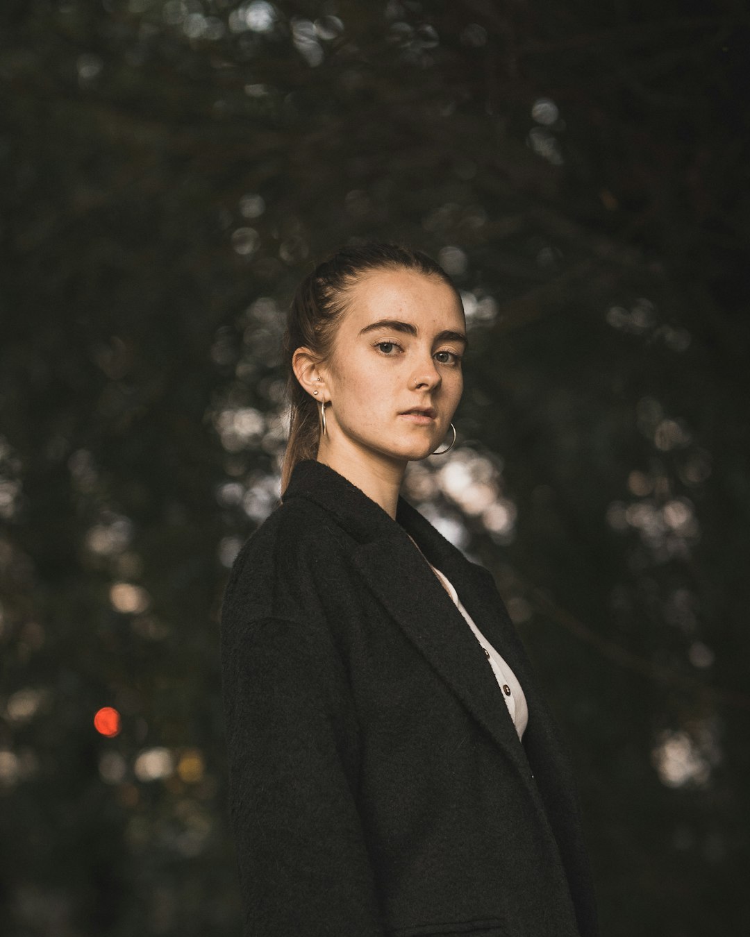 woman wearing black notched lapel suit jacket standing and looking straight