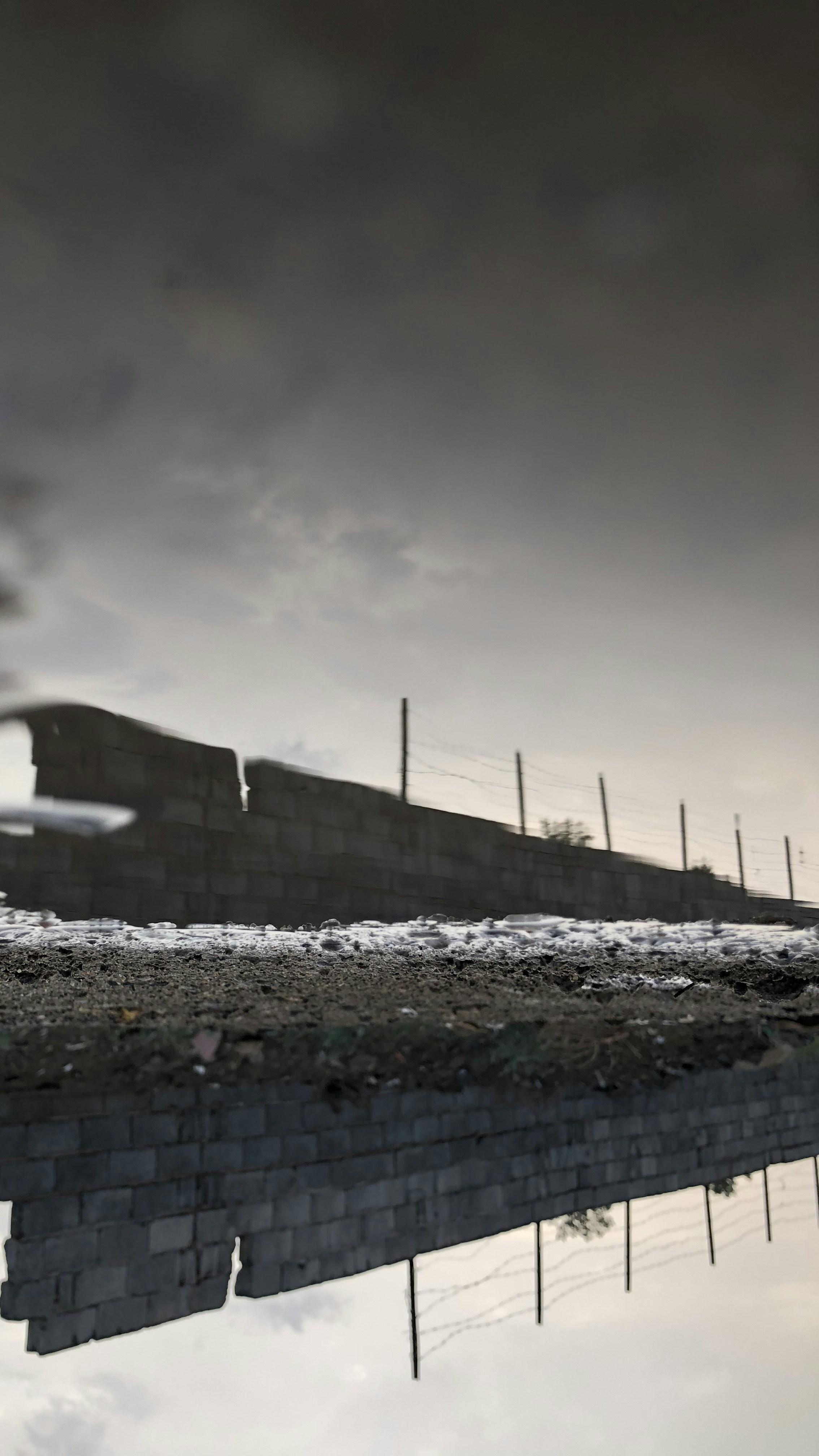 gray concrete blocks wall near body of water