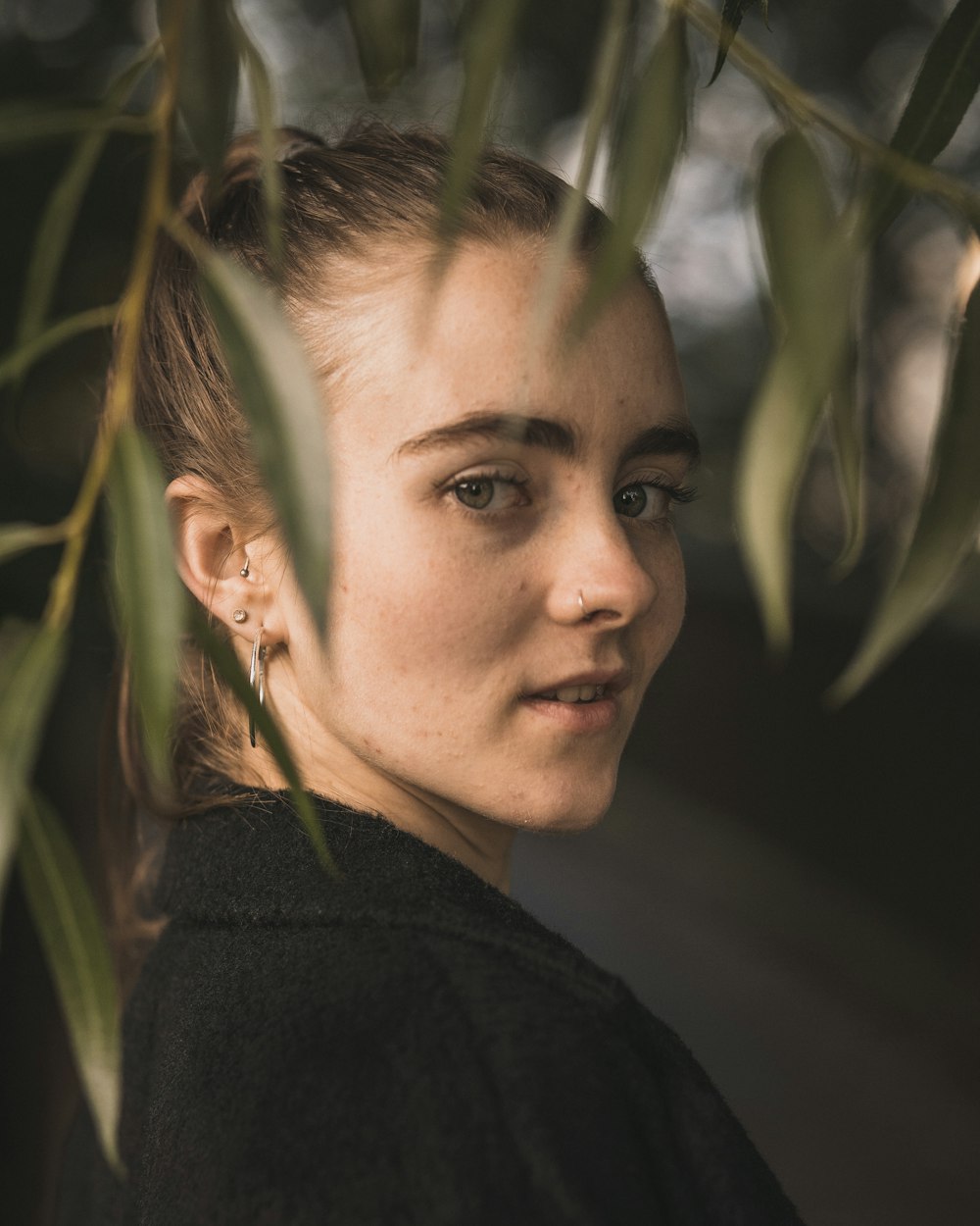 woman wearing black jacket standing while glancing her right side