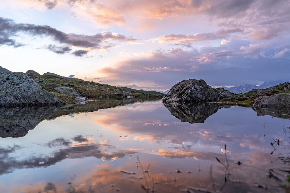 landscape photo of mountains near body of water under cloudy sky during daytime