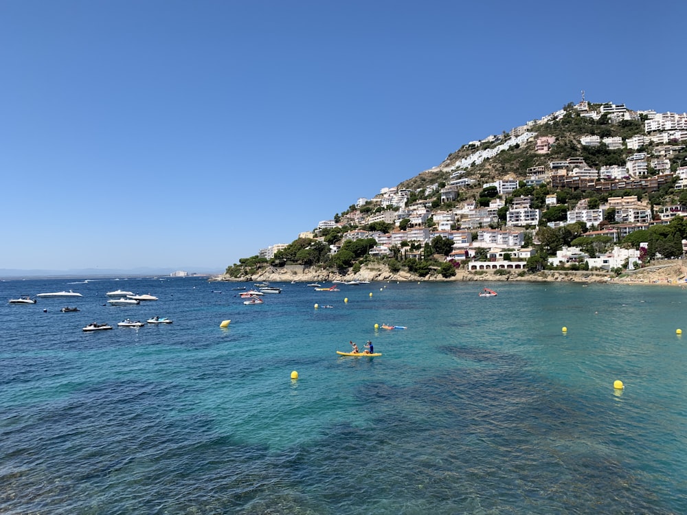 houses and building near mountain viewing blue sea during daytime