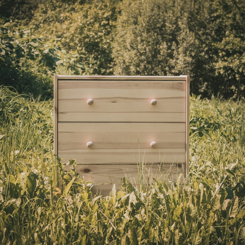 brown wooden 3-drawer chest on grass field