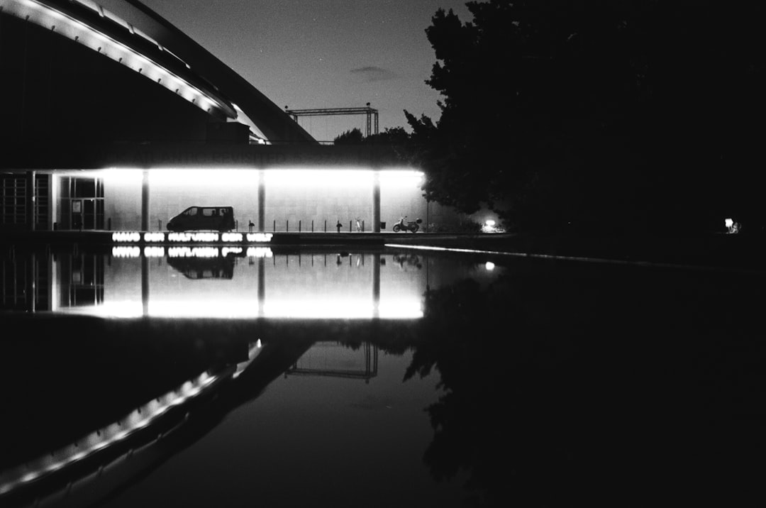 grayscale photography of vehicle near bridge
