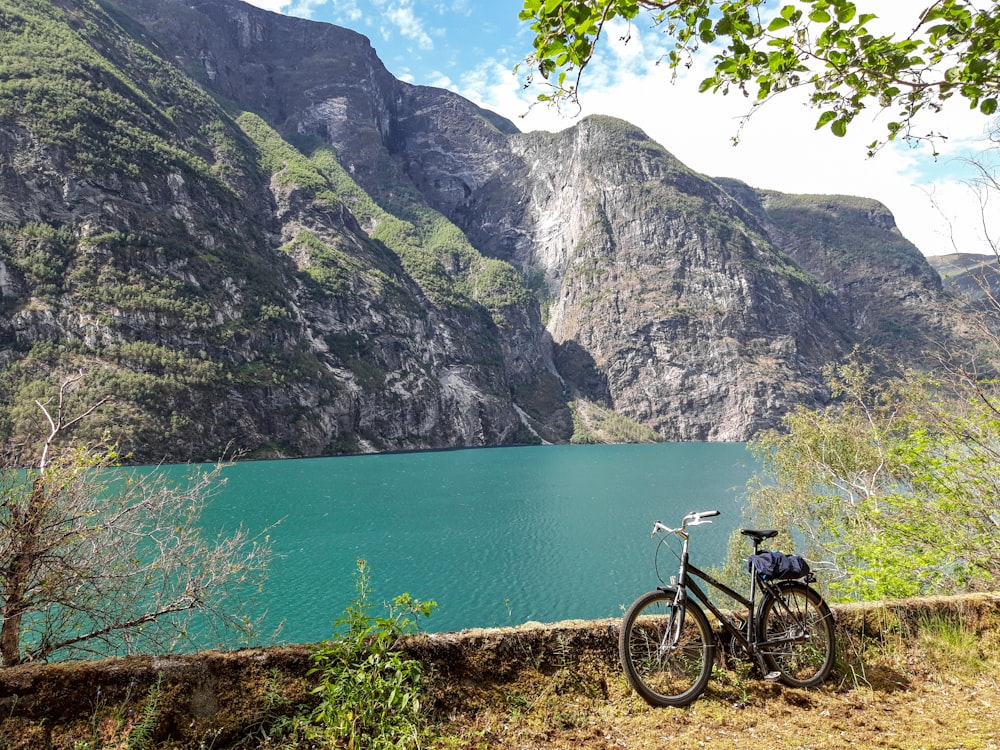 Bicicletta nera parcheggiata in piedi vicino allo specchio d'acqua