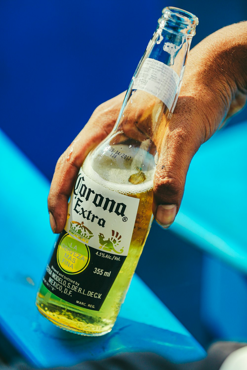 person holding Corona Extra bottle