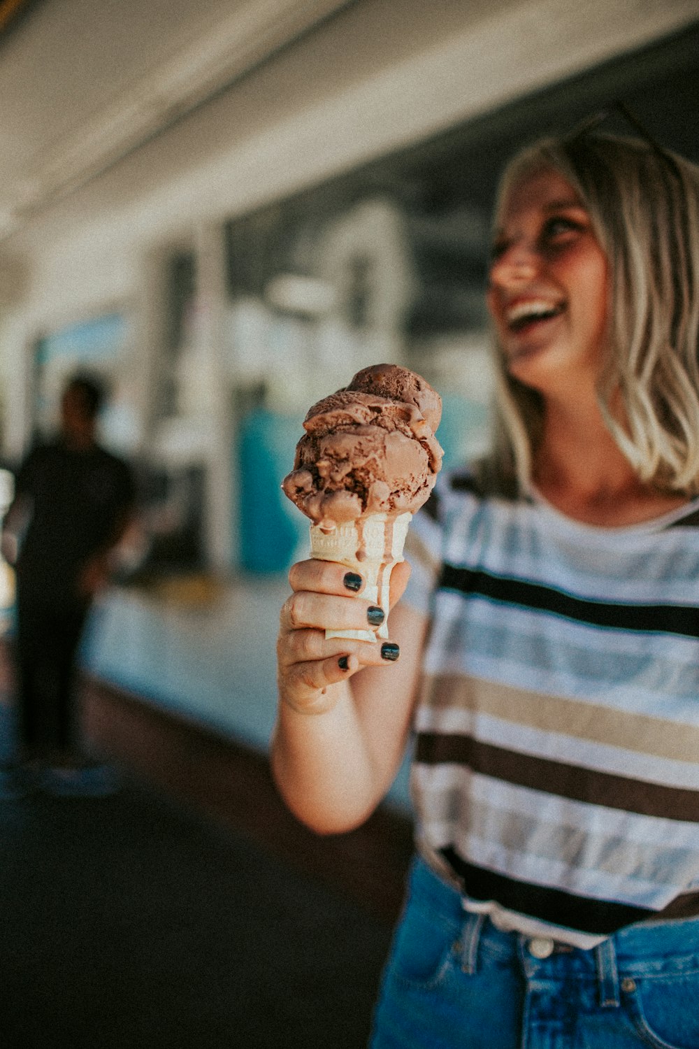 Mujer sosteniendo helado en cono y sonriendo