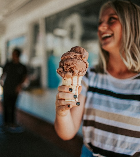 woman holding ice cream on cone and smiling