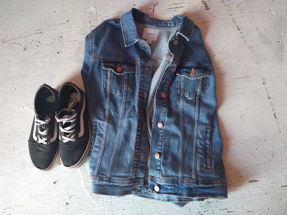 blue denim button-up vest beside sneakers