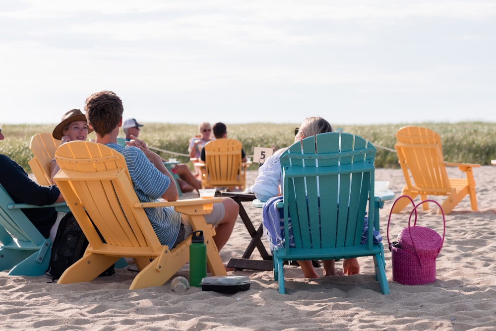 people sitting on outdoor chairs on shore