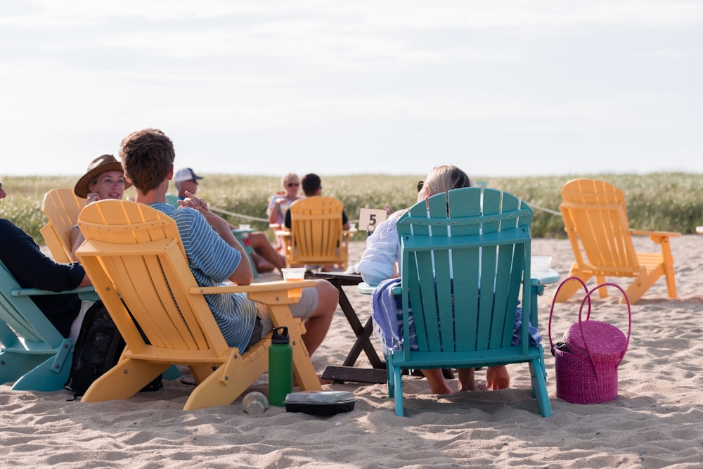 personnes assises sur des chaises d’extérieur sur le rivage