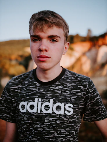man wearing black and white adidas crew-neck t-shirt
